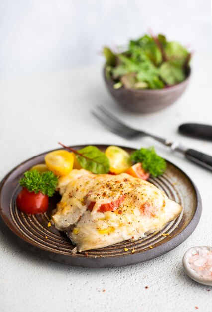 Photo a plate of chicken with tomatoes and salad on the side.