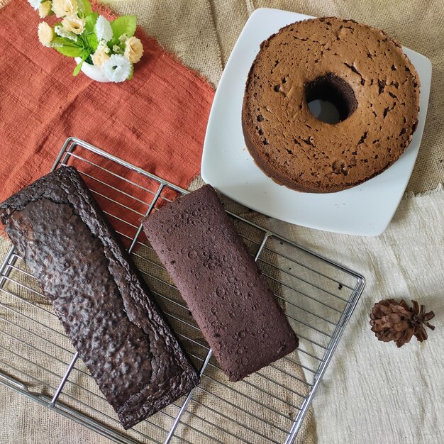 A plate of chocolate cake next to a cake on a table.