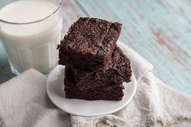 a plate of chocolate cake next to a glass of milk