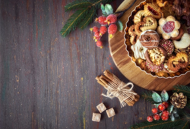 Plate of Christmas cookies on a wooden board with decorations