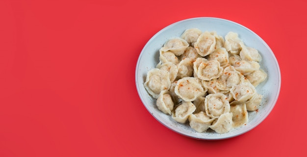 A plate of cooked dumplings in a dish on a trending  background, top view