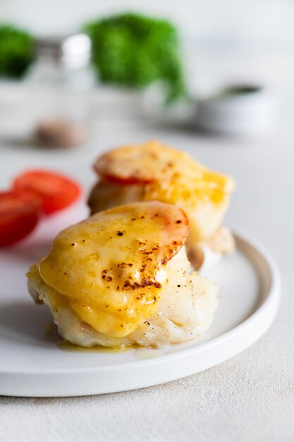 Photo a plate of crab cakes with a slice of tomato on the side.