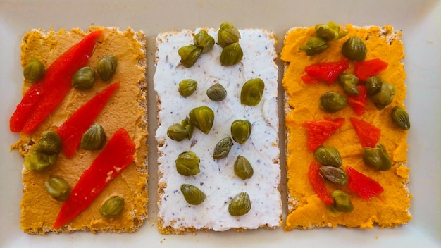 A plate of crackers with pumpkin seeds and pistachios