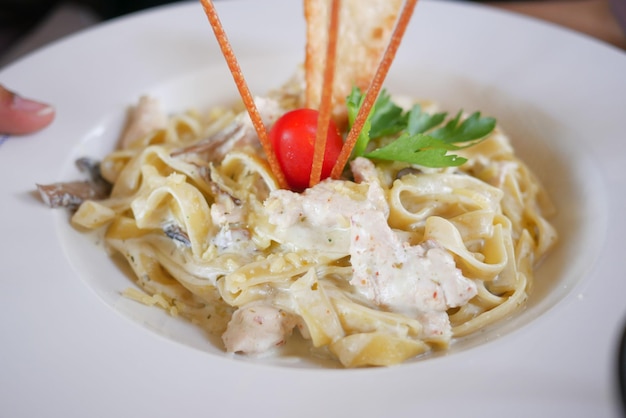 plate of cream and herb pasta on table