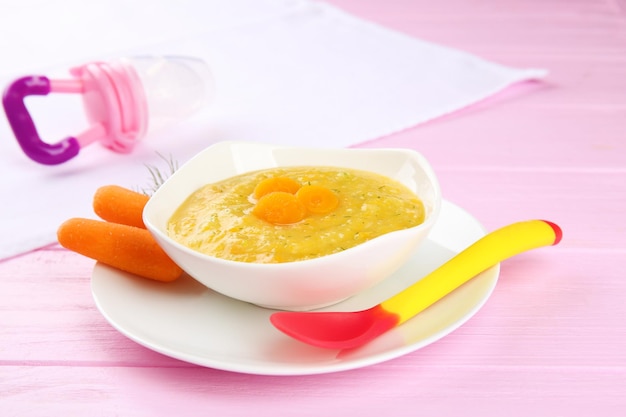 Тарелка сливочного детского овощного супа на столе