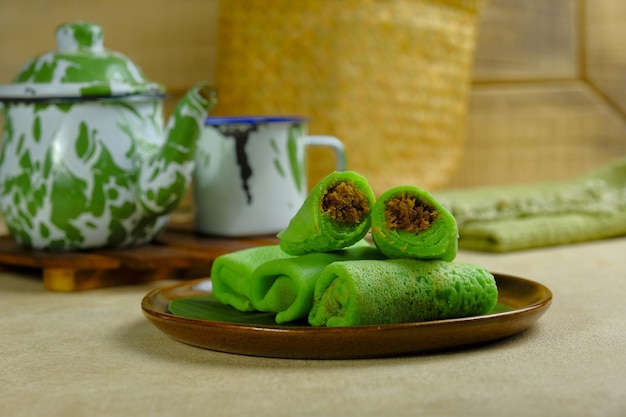 Photo a plate of dadar gulung indonesian roll crepe with grated coconut and palm sugar inside kue