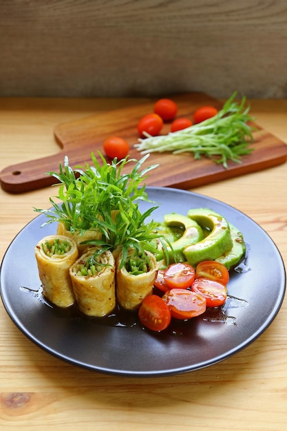 Plate of Delectable Egg Rolls with Fresh Water Spinach Microgreens Avocado and Tomato Salad