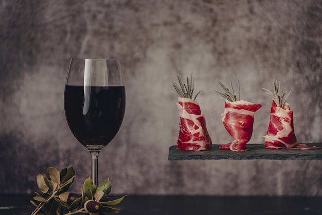 Plate of delicious Iberian ham on a wooden table background. Appetizing slices Iberian ham. Acorn-fed Iberico Ham. Pata negra, spectacular vision of sliced ham. Typical spanish food.