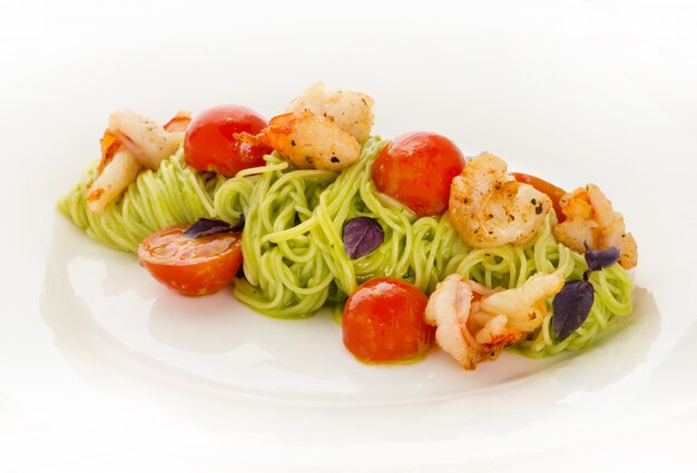 Тарелка вкусных итальянских спагетти с креветками и вишней
