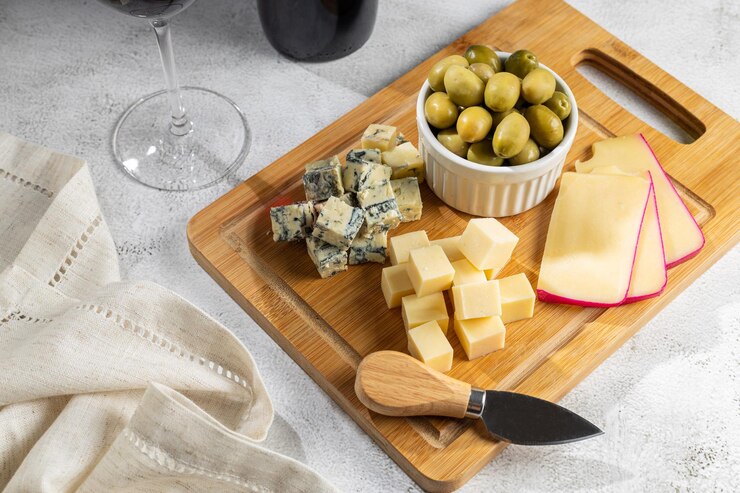 Photo plate of different cheeses with a glass of wine cheese board