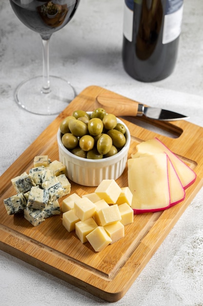 Plate of different cheeses with a glass of wine Cheese board