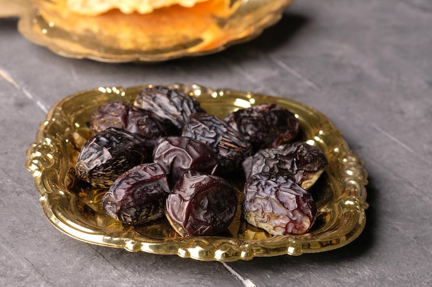 A plate of dried fruits on a table aiwa dates for Iftar in ramadan Kareem kurma ajwah