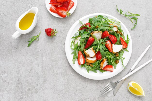 A plate of feta cheese salad with a fork and a bowl of olive oil on the side