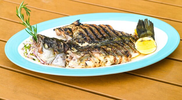 A plate of fish on a table with a lemon on it