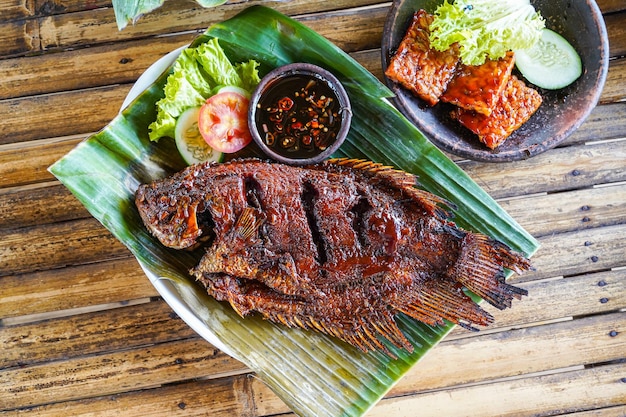 A plate of fish with a side of sauce next to it