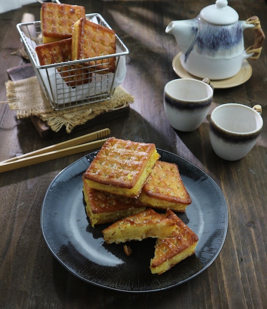 A plate of food with a basket of tea on the side.