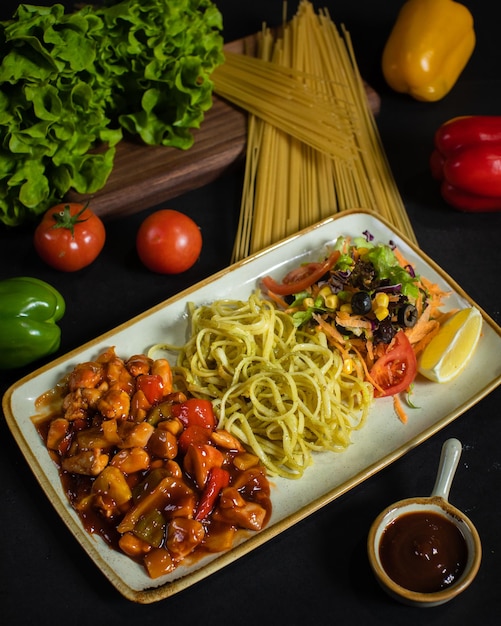 A plate of food with a bowl of pasta and a bowl of sauce.