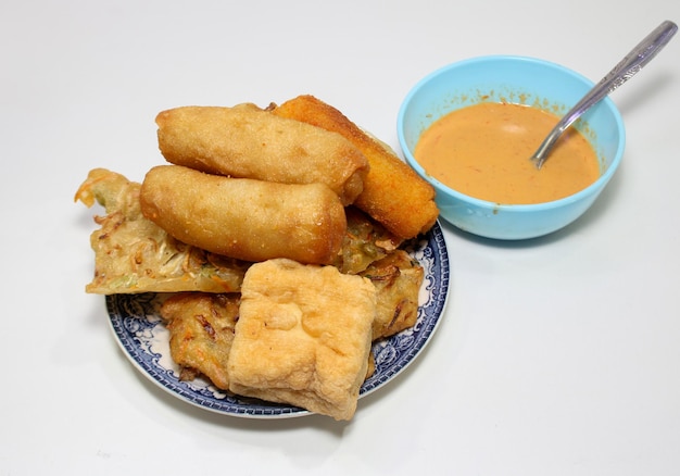 A plate of food with a bowl of sauce and a bowl of food.