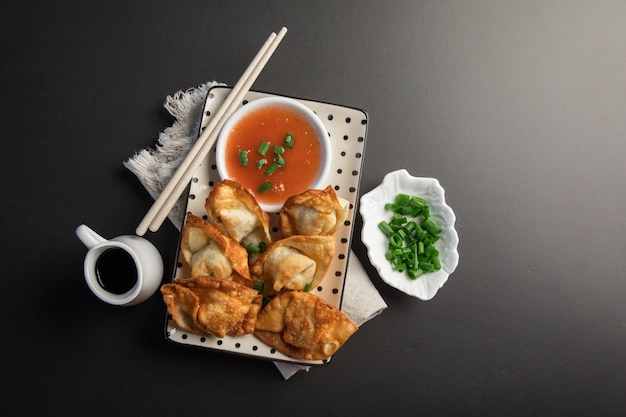 A plate of food with a bowl of soup and chopsticks on it.