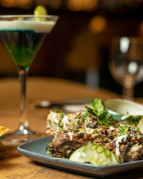 A plate of food with a drink in the background