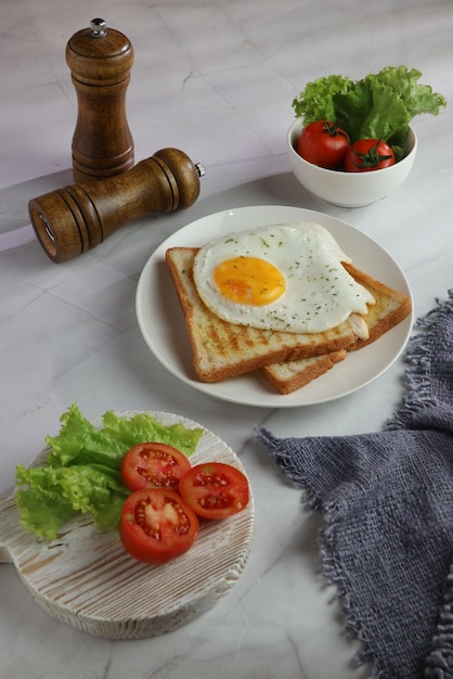 Photo a plate of food with a fried egg on it and a slice of bread on it.