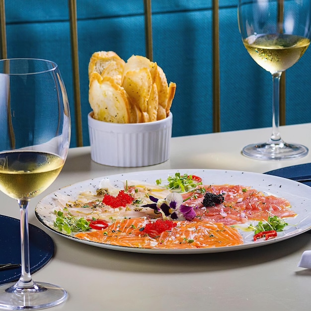 A plate of food with a glass of wine and a glass of wine on the table