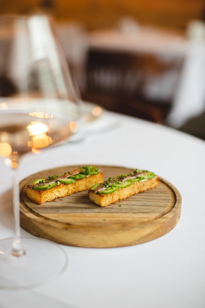 A plate of food with a glass of wine on the table