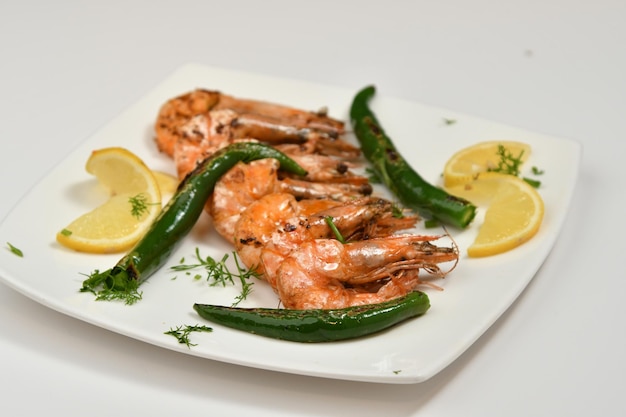 A plate of food with grilled shrimp and green vegetables.