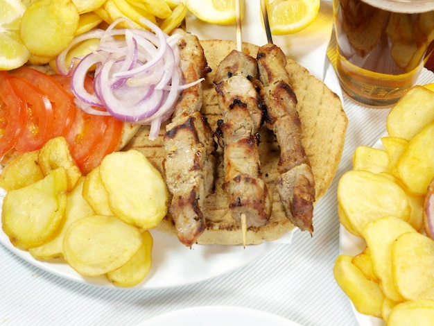 A plate of food with a plate of food and a glass of beer.