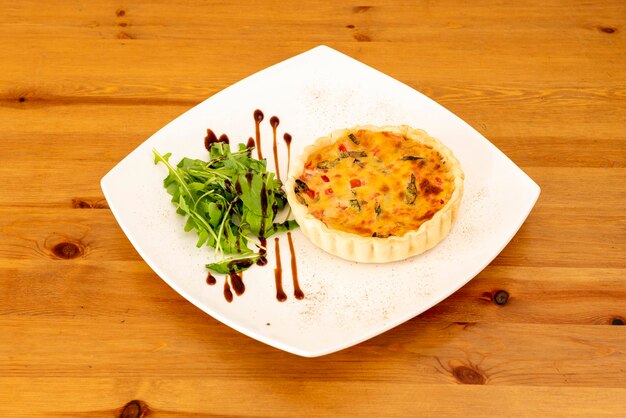 A plate of food with a quiche on it