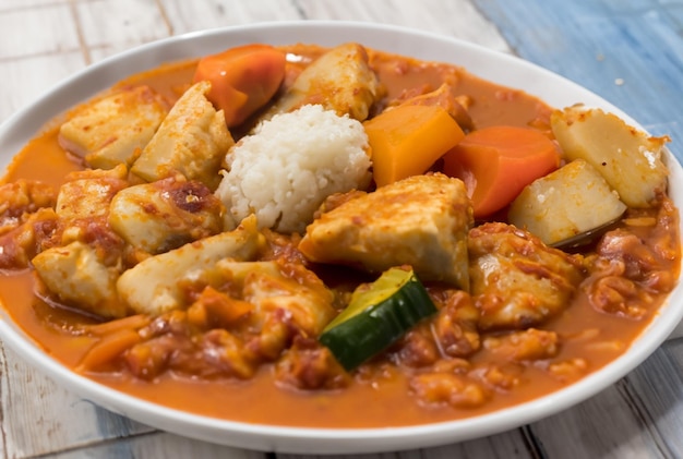 A plate of food with rice and vegetables on a wooden table