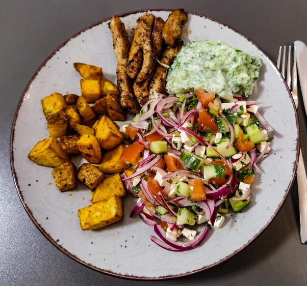 A plate of food with a salad and cucumber salad.