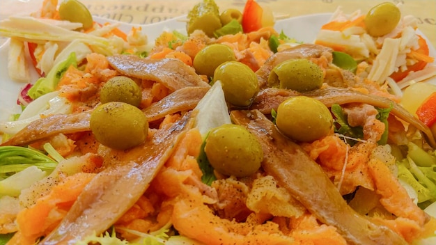 A plate of food with a salad and olives