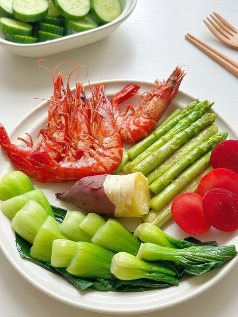 A plate of food with shrimp, cucumber, and cucumber