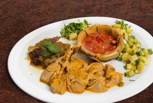 A plate of food with a small bowl of food on it