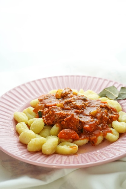 Plate of fresh gnocchi with tomato sauce and grated Parmesan cheese