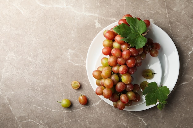 Plate of fresh grape on gray