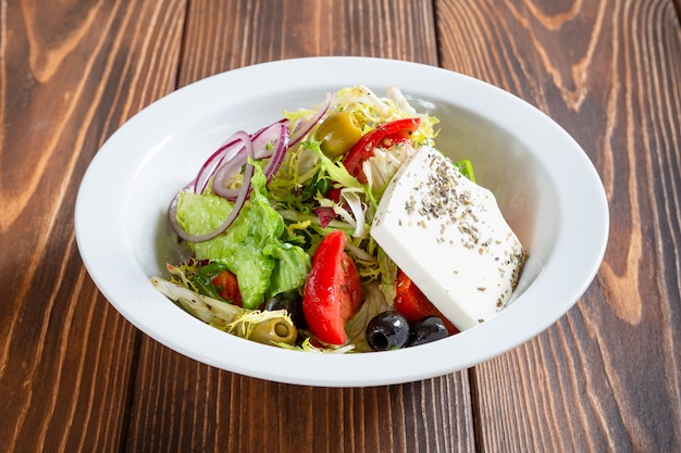 Foto piatto di insalata greca fresca sulla tavola di legno