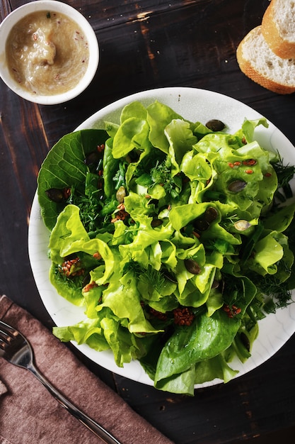 Тарелка свежего зеленого салата из семян льна темного дерева Диетическое питание