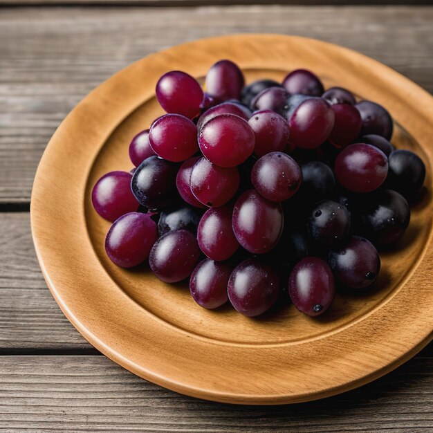 Plate of fresh ripe red grapes on wooden table close up