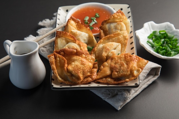 A plate of fried dumplings with a sauce on it