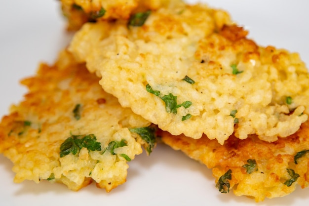 A plate of fried fish with a green herb on it.