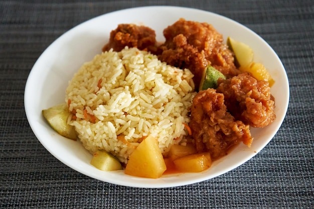 A plate of fried rice and fried chicken Asian cuisine