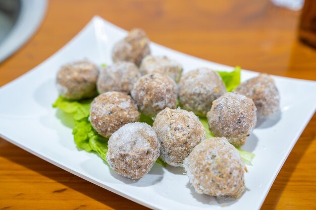 Photo a plate of frozen meatballs for the hot pot