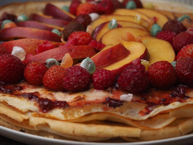 A plate of fruit is shown with a plate of pancakes and a plate of fruit.