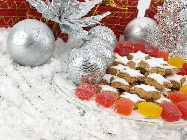 배경에 크리스마스 트리가 있는 진저브레드 쿠키 한 접시
