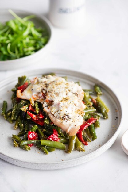 Photo a plate of green beans with a salmon and asparagus dish.