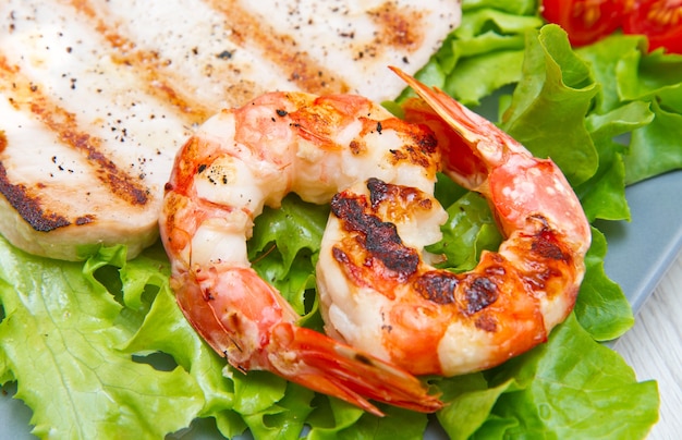 Plate of grilled fish with salad and cherry tomatoes