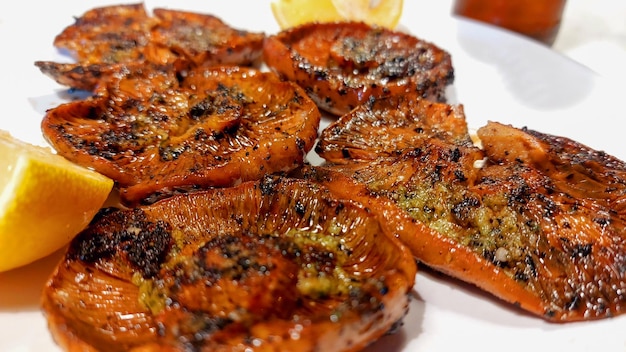 A plate of grilled salmon with a lemon wedge on the side.