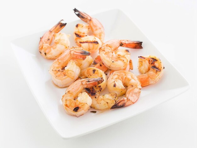 A plate of grilled shrimp with a white background